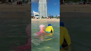 Cheerful children turned their father into a boat while enjoying the beach. Funny Beach Swimming!