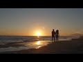 Young couple walking along beach in sunset holding hands - Free Video Footage