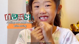 自己拔乳牙Pulling out baby tooth with string ［好玩小孩」