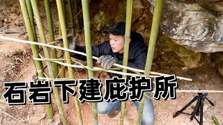 流浪者在密林里搭建庇护所，藏在石岩下。无人机下，非常隐蔽