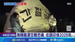 南韓籠罩空難悲痛 低調迎接2025年 機場鐵絲網掛哀悼信 燒酒奠祭亡魂致哀 空難悲痛壟罩 寺廟敲鐘盼\