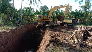 excavator komatsu sedang menggali lobang