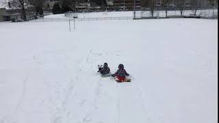 小宝六岁两个月，自闭症。小宝和阳阳坐在滑雪板上滑雪。