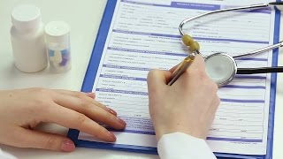 Female M.D. filling out patient registration form, keeping clinical records. Stock Footage
