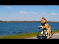 An Lion riding a road cycle along a lakeside path