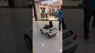 Kid driving car in a mall