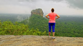 Woman looking at Sigiriya Rock or Lion's Rock and the surrounding Sri Lankan Jungle