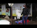 a bulawayo city centre worker sprays the body of a woman who fell and collapsed with a disinfectant.