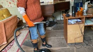 Vacuuming the lounge, cleaning the fire ash, with orange rubber gloves