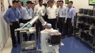 Manpower Minister Lim Swee Say observing a robot demonstration