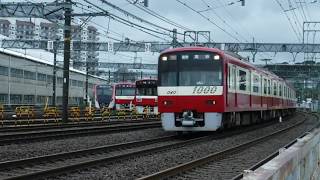 雨が降る京急線金沢文庫～金沢八景駅間を、京急沿線の風景ギャラリー号エアポート急行新逗子行き1000形と快特高砂行き1000形040がすれ違いながら走行中！浅草ラインエアポート急行5500形が停車中！