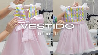 Costurando laço de tecido para vestido de festa infantil.