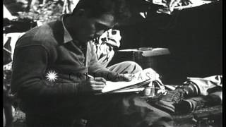 A soldier seated outside a tent writes a letter in Charmois, France, in World War...HD Stock Footage