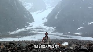 瑜伽士坐在雪地里打坐冥想，提着一个钵盂光着双脚走在积雪上