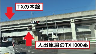 つくばエクスプレスと立体交差する道路から見た入出庫線を走行して車両基地に向かうTX1000系