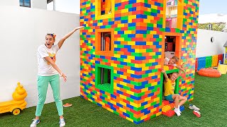 व्लाद और निकी रंगीन खिलौना ब्लॉकों के साथ खेलते हैं और थ्री लेवल हाउस बनाते हैं