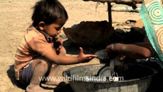 A child helps his mother, Gujarat