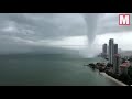 apocalyptic water tornado speeds towards city leaving buildi