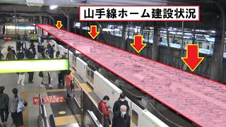 旧3番線を埋めて京浜東北線北行ホームと一体化される工事が進む品川駅山手線外回りホームと到着するE235系