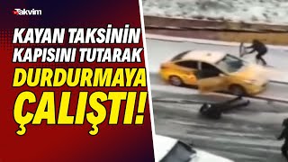 Karda kayan taksinin kapısını tutarak durdurmaya çalıştı! Yolcu ise yere böyle düştü... İlginç anlar