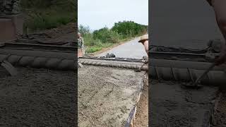 Concrete road paving process with a single-axis roller