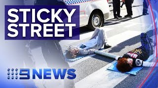 Adani mine protestors glue themselves to busy Brisbane street | Nine News Australia