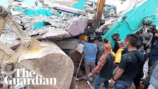 Indonesia earthquake: rescue workers search rubble with dozens reported dead