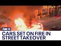 Street takeover in downtown LA ends with 2 cars burned