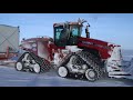 winter antarctic traverse tractor being escorted by two hagglunds