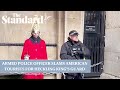 Armed police officer confronts American tourists for heckling member of King's Guard