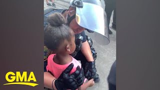 Police officer comforts little girl after she asks: 'Are you going to shoot us?' l GMA Digital