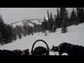 snowmobile climbing up steep hills and through trees