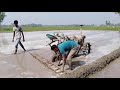 Power Tiller driver Level the soil of the paddy field with a ladder