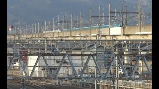 一ノ関駅を通過して山並みの中に消えていく東北新幹線はやぶさと秋田新幹線こまちの併結列車