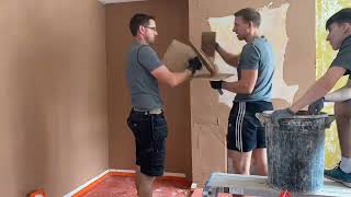 Plastering a fire place wall.