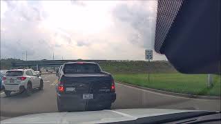 Be kind a truck letting a car in traffic at the stoplight.