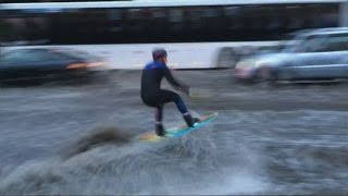 Man wakeboarding down a busy flooded Moscow street