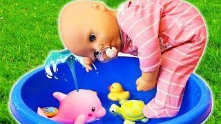 Baby Annabell doll plays with water toys in a colorful container. Baby dolls videos for kids.