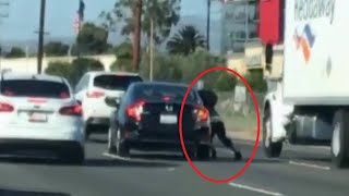 VIDEO: Woman clings to car during apparent road rage incident