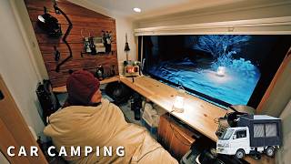 Car camping in the harsh snowy mountains. The new homemade light truck camper is comfortable.