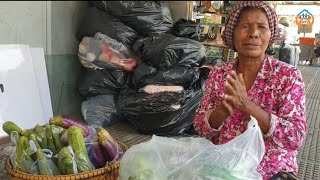 Khmer-Americans donate money to an elderly woman selling vegetables at Central Market