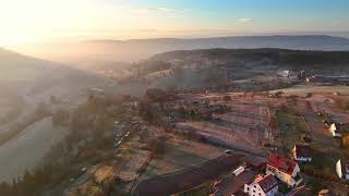 Flight over magnificent countryside and small town in Southern Germany at sunrise