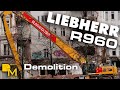 Liebherr R960 high reach crawler excavator ripping down historical building downtown with 32m boom