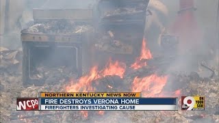 Woman looks on as fire destroys her Verona home