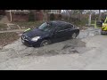 Car in Albany Park partially swallowed by sinkhole