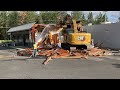 entire strip mall absolutely demolished by an excavator