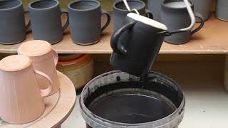 Studio Pottery Technique - Glaze dipping a mug.