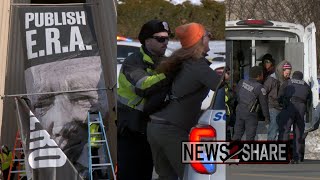 Activists dressed as contractors hang banner demanding Equal Rights Amendment at National Archives