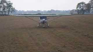 Ikarus C42 landing in a field.