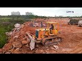 perfectly skill dozers push mush stone and trees to filling up huge area with dump trucks processing